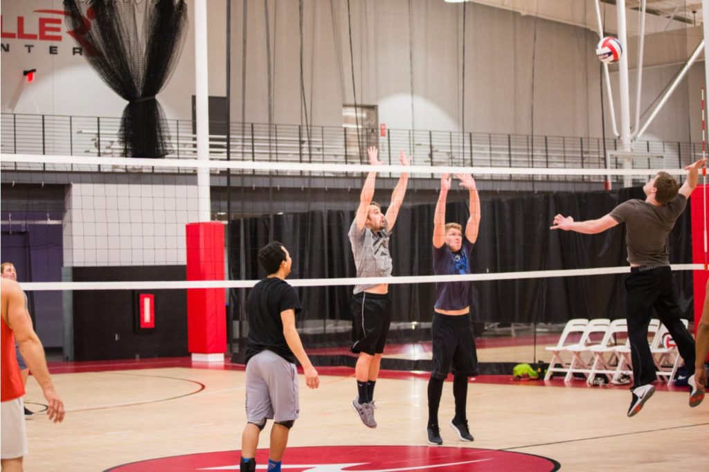 Guys playing volleyball with each other