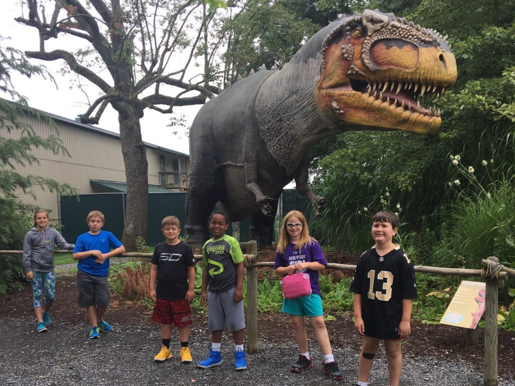 summer camp kids in front of animatronic t-rex at Reptiland