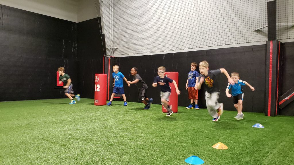 kids running on the indoor turf for homeschool gym class