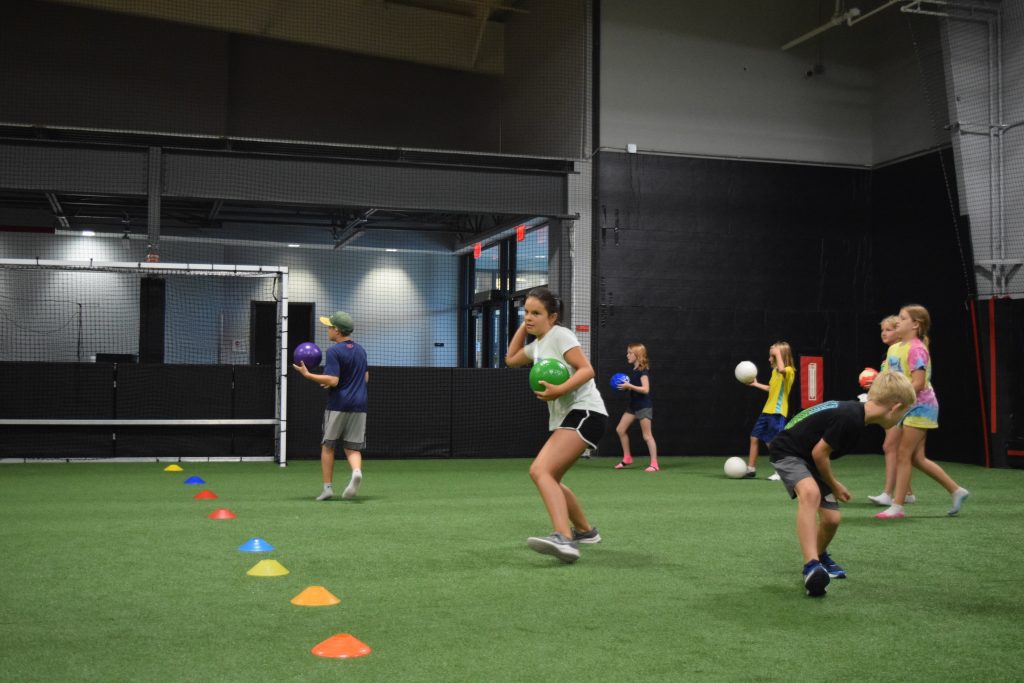 kids playing dodgeball on the YMCA turf field